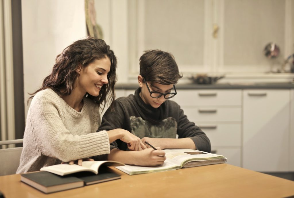 older sister helping her teenage brother to study