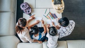 A parent teaches her children from home.