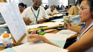 A grade 12 teacher marks exam scripts.