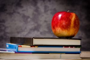 An apple on a pile of books.